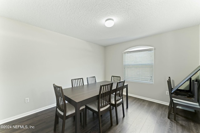 dining room with dark hardwood / wood-style floors and a textured ceiling