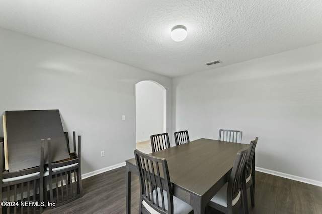 dining room featuring dark hardwood / wood-style flooring and a textured ceiling