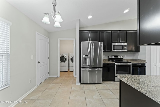 kitchen with washing machine and clothes dryer, pendant lighting, lofted ceiling, and appliances with stainless steel finishes