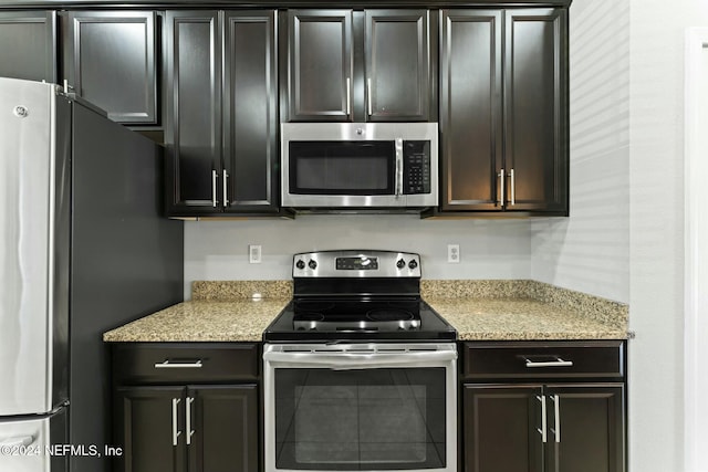 kitchen with appliances with stainless steel finishes and light stone counters