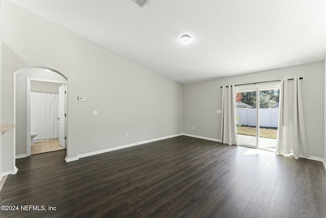 unfurnished room with dark hardwood / wood-style flooring and a textured ceiling