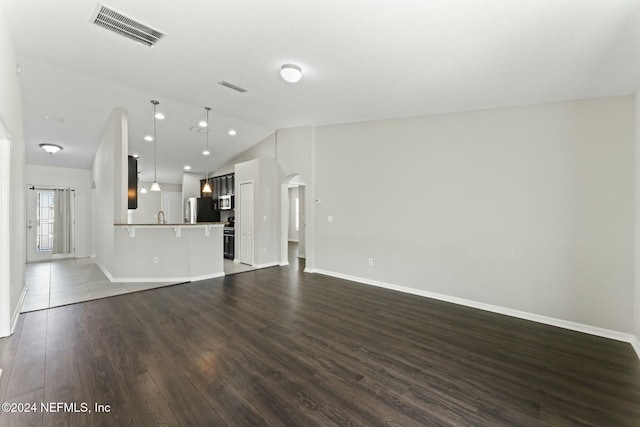 unfurnished living room featuring wood-type flooring and lofted ceiling