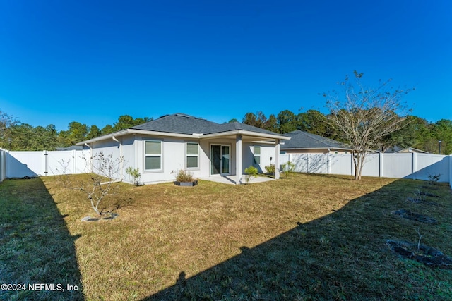 back of property featuring a yard and a patio