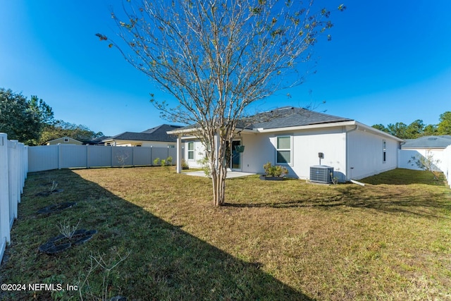 back of property featuring cooling unit, a patio area, and a yard