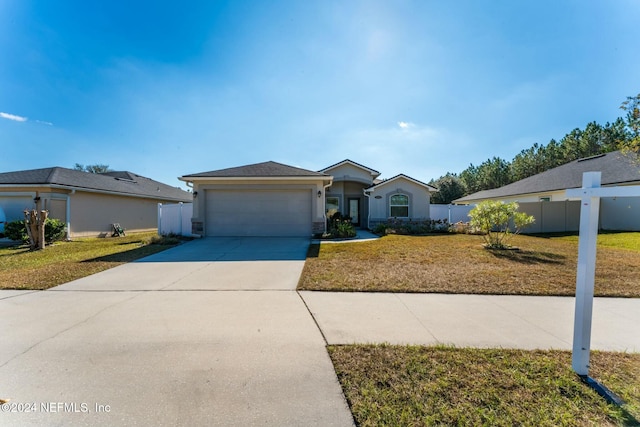 ranch-style house featuring a garage and a front lawn