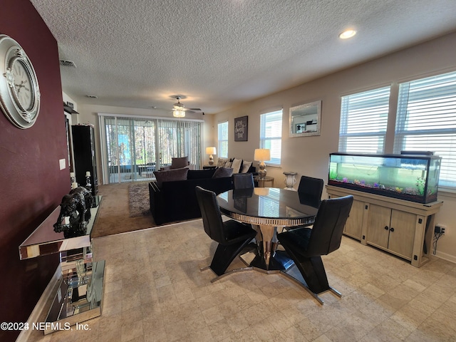 dining space with ceiling fan and a textured ceiling