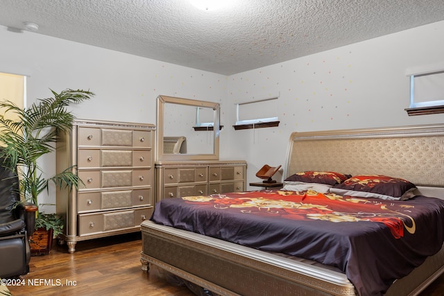 bedroom featuring a textured ceiling and dark hardwood / wood-style floors