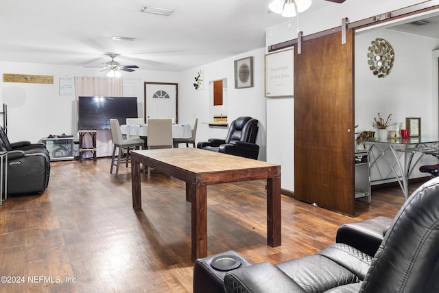 interior space with a barn door, hardwood / wood-style flooring, and ceiling fan