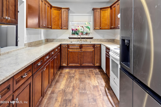 kitchen featuring light stone counters, sink, dark wood-type flooring, and white appliances