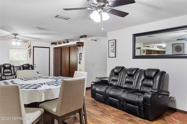 dining area with hardwood / wood-style floors, ceiling fan, and a textured ceiling