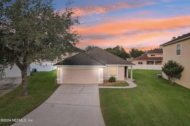 view of front of house with a garage and a yard