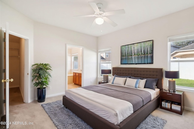 carpeted bedroom with connected bathroom and ceiling fan