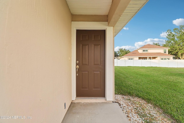 doorway to property featuring a lawn