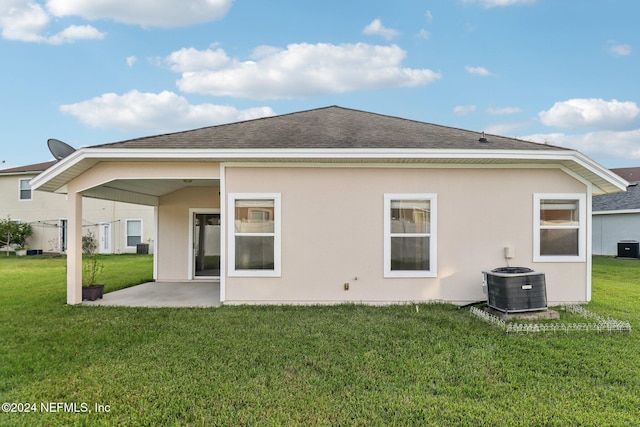 rear view of house featuring a yard, a patio, and central AC