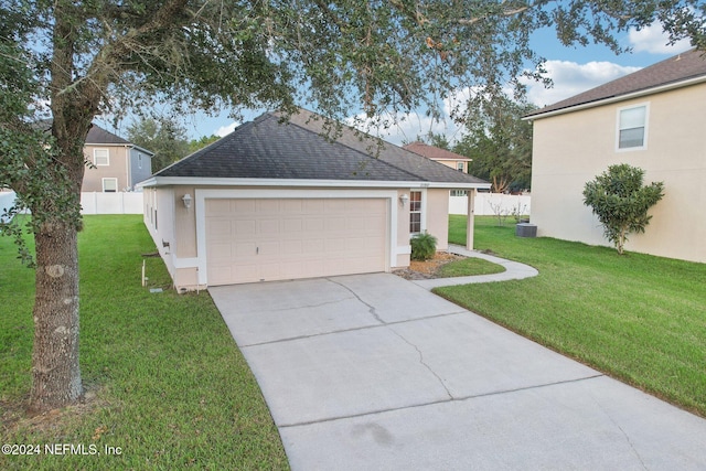 exterior space with cooling unit, a garage, and a front lawn