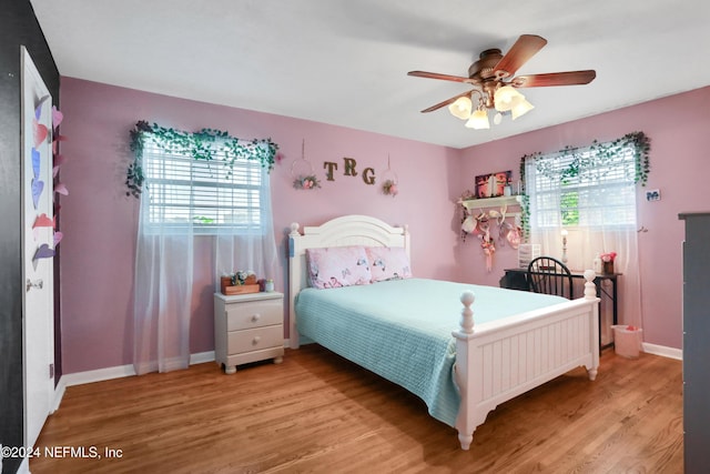 bedroom with multiple windows, ceiling fan, and light wood-type flooring