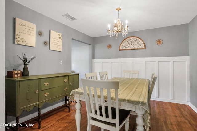 dining space with a notable chandelier and dark hardwood / wood-style flooring