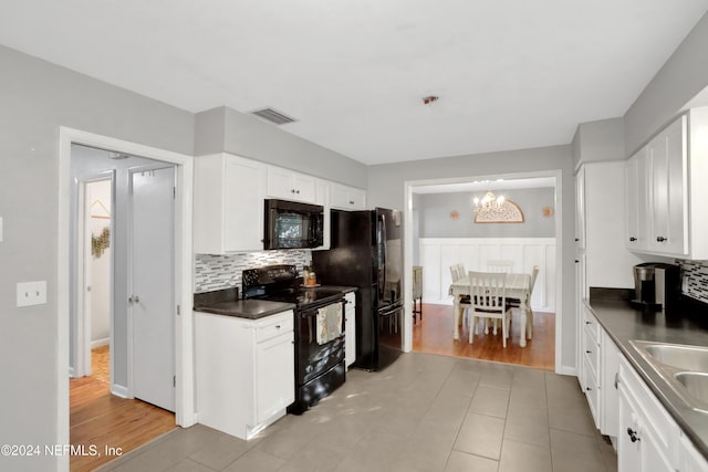 kitchen featuring white cabinets, light hardwood / wood-style floors, and black appliances