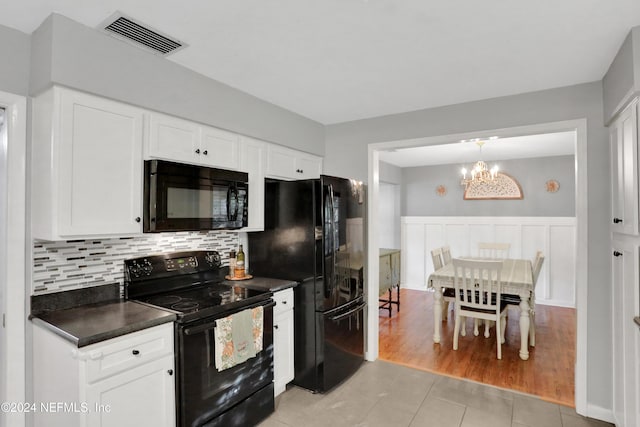 kitchen with backsplash, an inviting chandelier, black appliances, light hardwood / wood-style flooring, and white cabinetry