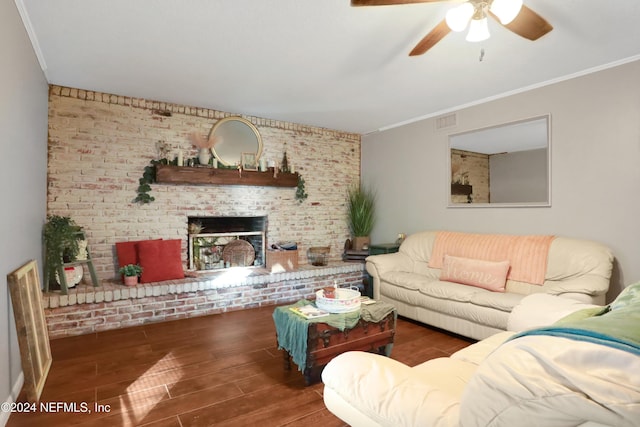 living room featuring ceiling fan, a brick fireplace, brick wall, dark hardwood / wood-style floors, and ornamental molding