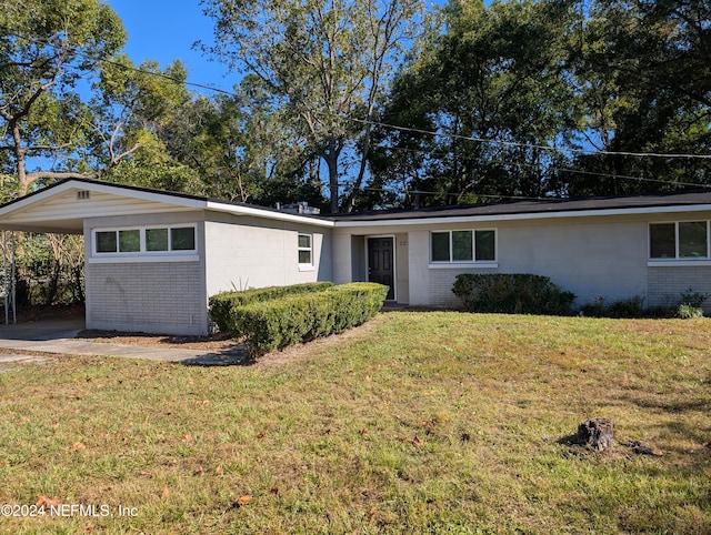 ranch-style home featuring a front lawn and a carport