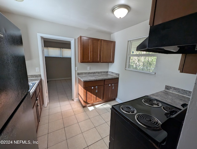 kitchen with stainless steel fridge, electric range, light tile patterned flooring, and extractor fan