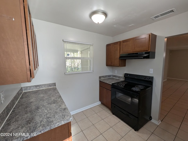 kitchen with black electric range and light tile patterned floors