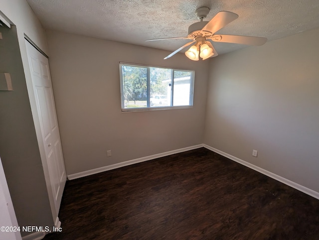 unfurnished bedroom with dark hardwood / wood-style flooring, ceiling fan, a closet, and a textured ceiling