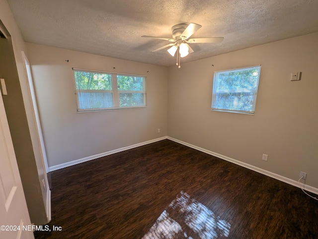 spare room with a textured ceiling, ceiling fan, and dark wood-type flooring