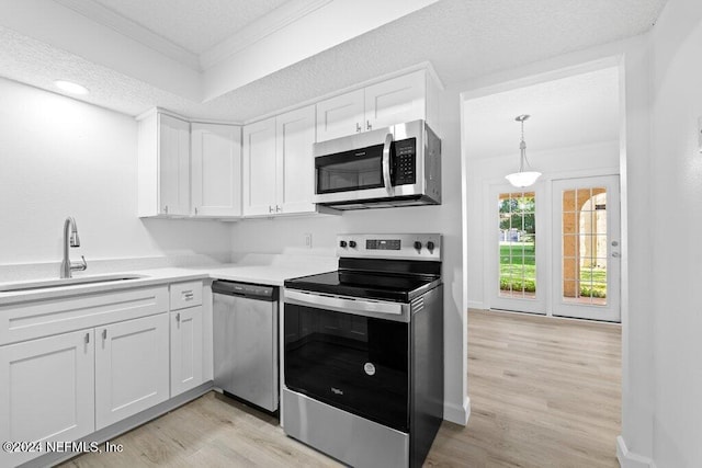 kitchen featuring white cabinets, a textured ceiling, stainless steel appliances, and sink