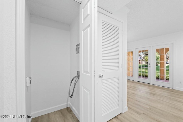 hallway featuring french doors and light hardwood / wood-style flooring