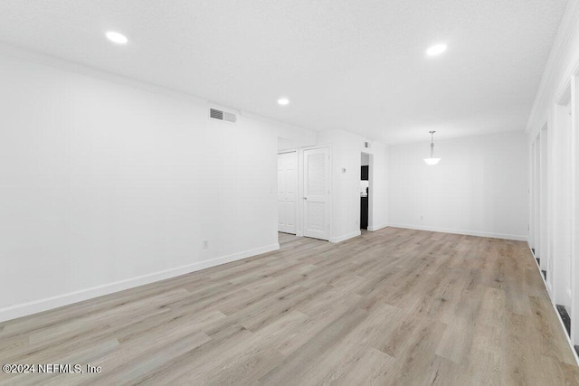 unfurnished living room with light hardwood / wood-style floors and ornamental molding