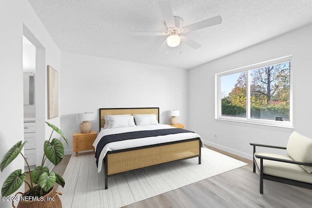 bedroom featuring a textured ceiling, light hardwood / wood-style floors, and ceiling fan