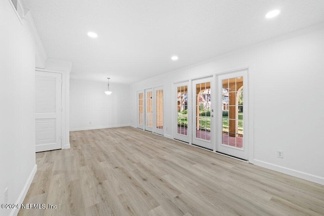 empty room featuring crown molding and light hardwood / wood-style floors