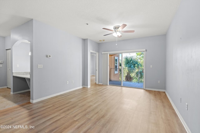 spare room with a textured ceiling, light hardwood / wood-style flooring, and ceiling fan