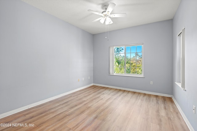 empty room with light hardwood / wood-style flooring and ceiling fan