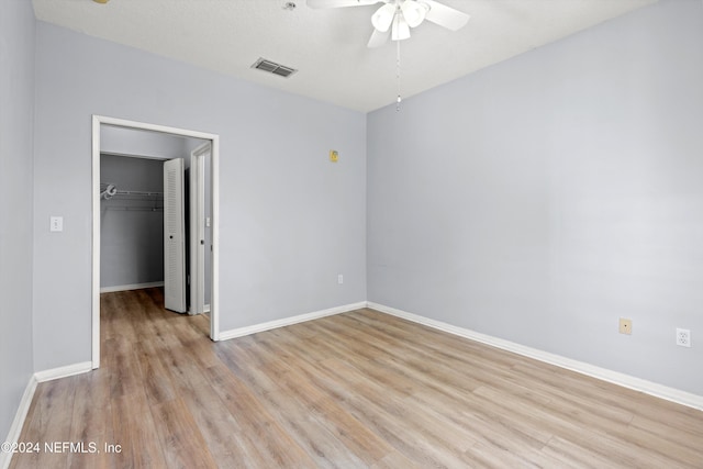 unfurnished bedroom featuring ceiling fan, light wood-type flooring, and a closet