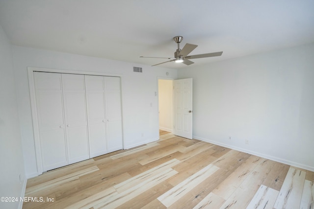 unfurnished bedroom featuring ceiling fan, light hardwood / wood-style floors, and a closet