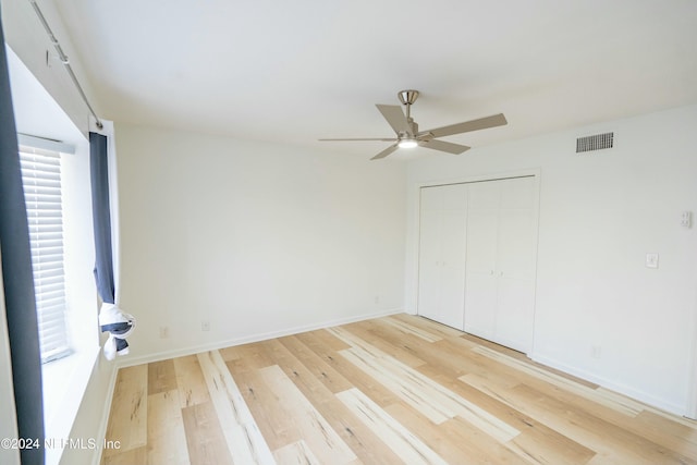 unfurnished bedroom featuring wood-type flooring, a closet, and ceiling fan