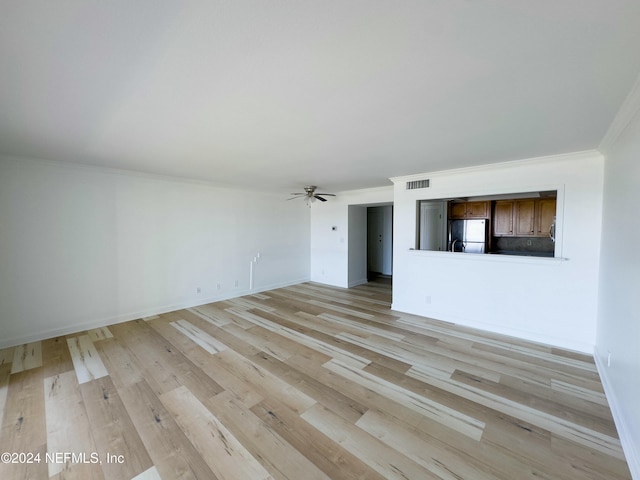 unfurnished living room with crown molding, ceiling fan, and light wood-type flooring