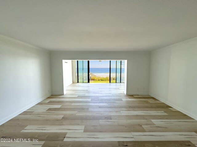 spare room featuring crown molding and light hardwood / wood-style flooring