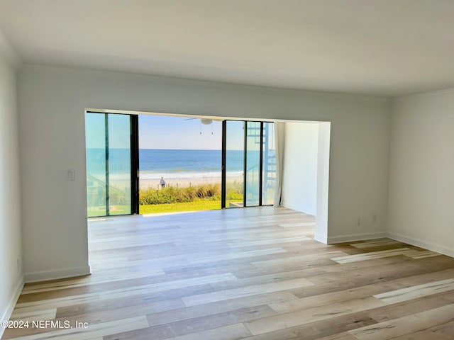 empty room featuring a water view and light wood-type flooring