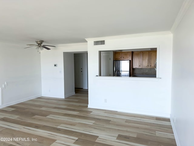 unfurnished room featuring ceiling fan, ornamental molding, and light wood-type flooring