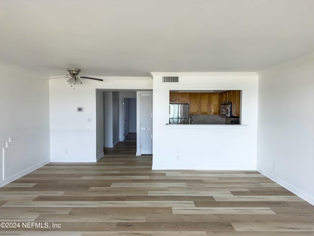 unfurnished living room with ceiling fan, crown molding, and light hardwood / wood-style flooring