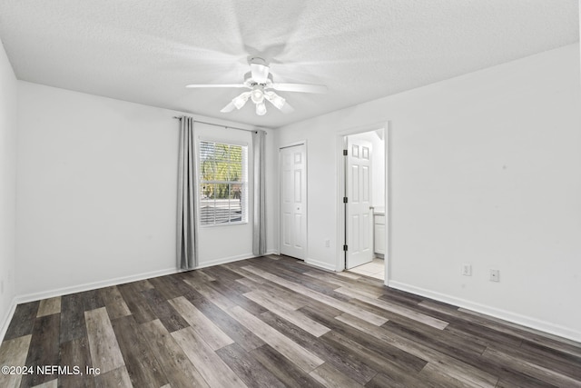 spare room featuring dark hardwood / wood-style floors, ceiling fan, and a textured ceiling