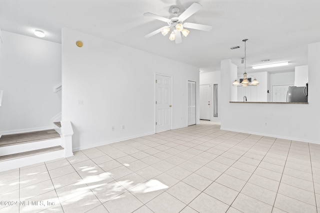 unfurnished living room featuring ceiling fan with notable chandelier and light tile patterned floors