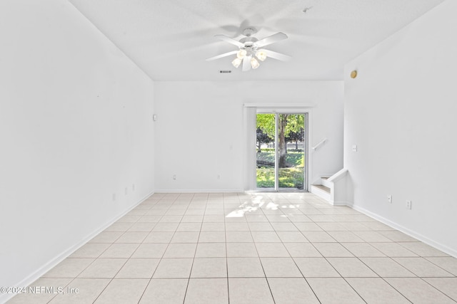 tiled spare room with ceiling fan