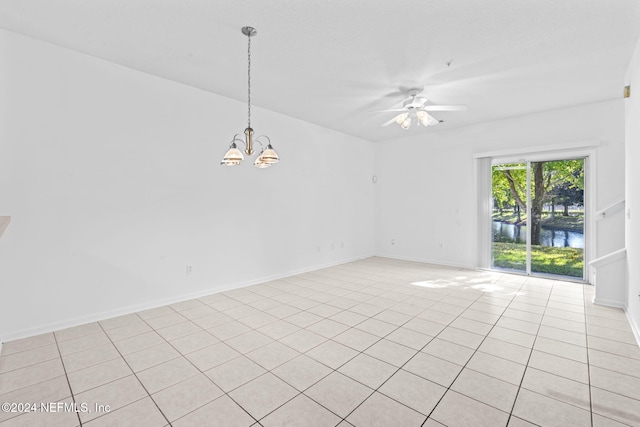 unfurnished room featuring light tile patterned floors, ceiling fan with notable chandelier, and a water view