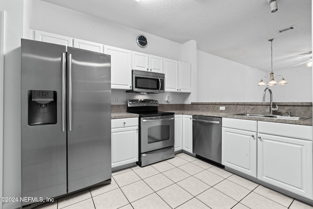 kitchen with pendant lighting, sink, a textured ceiling, white cabinetry, and stainless steel appliances