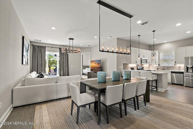 dining space featuring a notable chandelier, a textured ceiling, and hardwood / wood-style flooring